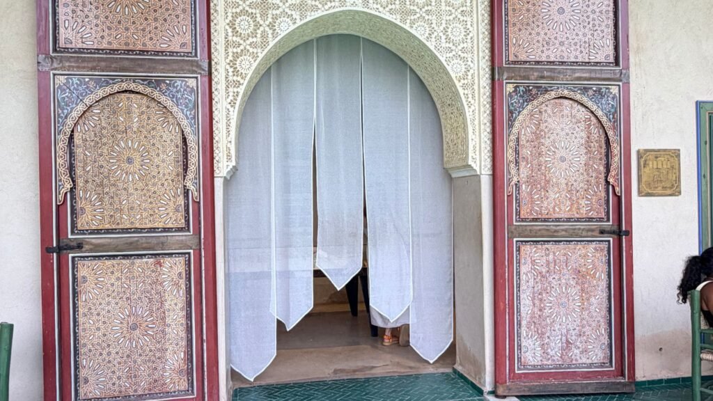 Architecture marocaine traditionnelle et végétation luxuriante au Jardin Secret de Marrakech.