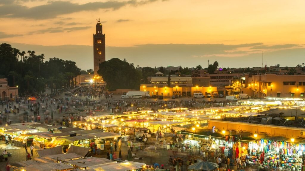 Place Jemaa el-Fna à Marrakech au coucher du soleil avec ses restaurants, musiciens et ambiance unique.